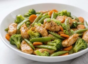 Chicken stir fry with frozen vegetables recipe ready in 20 minutes, featuring glossy sauce-coated chicken and colorful vegetables